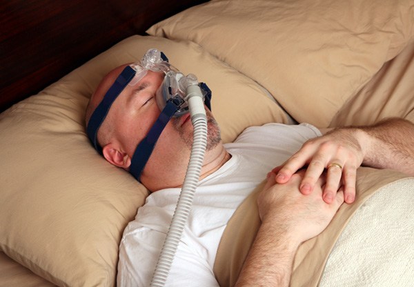 young woman smiling while looking in dental mirror