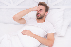 Man with sleep apnea lying awake in bed