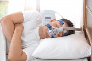 Man sleeping with CPAP machine on.