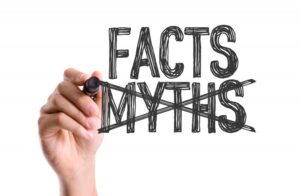 hand crossing out Myths and writing Facts
