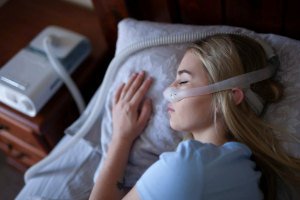Woman sleeping in bed with CPAP machine