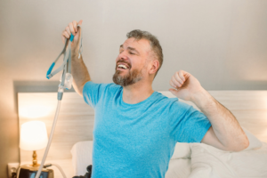 a man smiling and holding his CPAP machine
