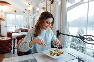 Woman sitting at table in restaurant enjoying a meal